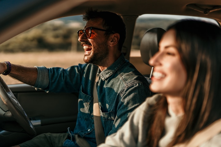 Two people laughing inside of a car