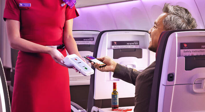 Image of a man paying for an onboard purchase