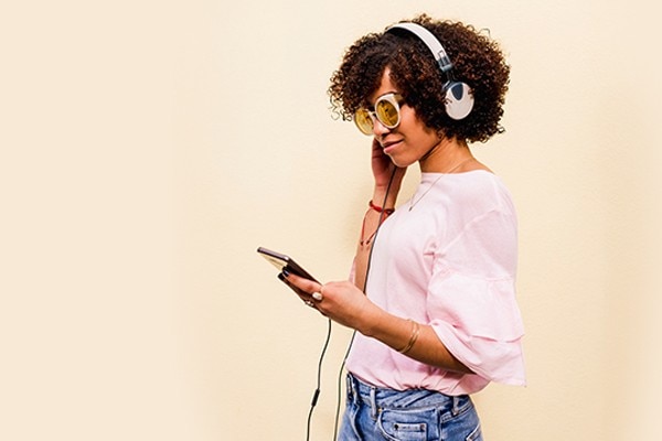 Image of person with headphones on looking at phone