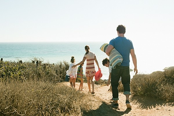 family walking toward a beach