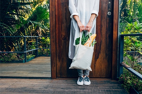 Person standing with a bag of goods