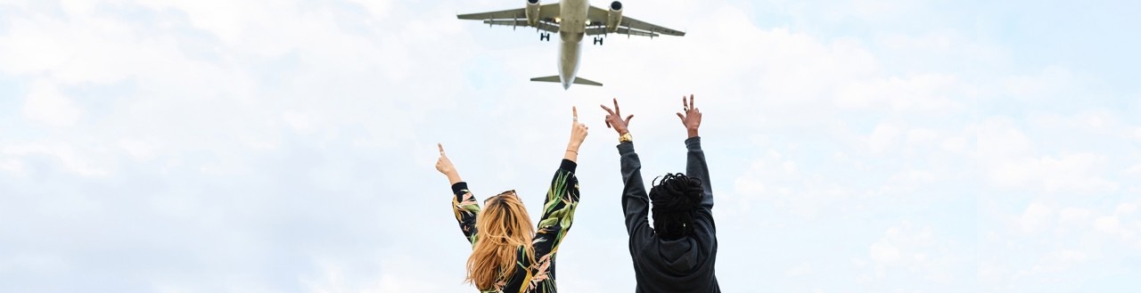 Couple pointing at plane in the sky