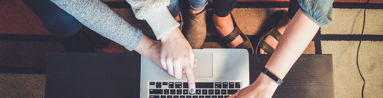 Couple pointing at laptop screen